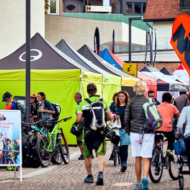 fila di gazebo 4x4 m nero e lime con pareti laterali logo Ergon al Brixen Bike Festival