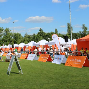 White and orange 6x3 gazebo with decorative pole cover tents and customised ING DiBa flags at sponsored sports event in Germany