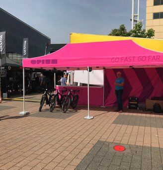 Gazebo pieghevole fuxia 6x3 personalizzato con logo Opium e diversi teli laterali all'Eurobike in Svizzera fa da stand delle biciclette.