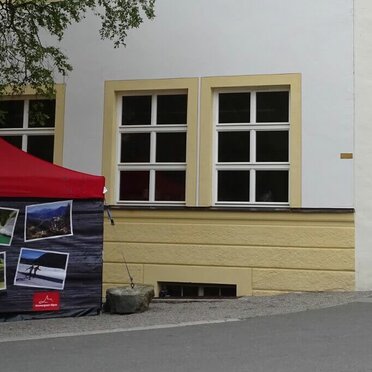 Gazebo 4,5x3 rosso con telo grigio personalizzato con stampa utilizzato come infopoint per il Parco Naturale delle Alpi