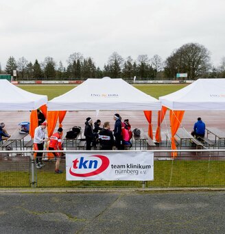 Serie di gazebo per eventi 6x3m bianchi con tende angolari arancioni personlizzati con logo IngDiba per evento all'aperto su un grande campo sportivo