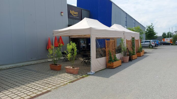 2 gazebo pieghevoli di 4,5 x 3 m si trovano davanti al panificio Käser di Vilshofen. Servono come tettoie per gli ospiti.